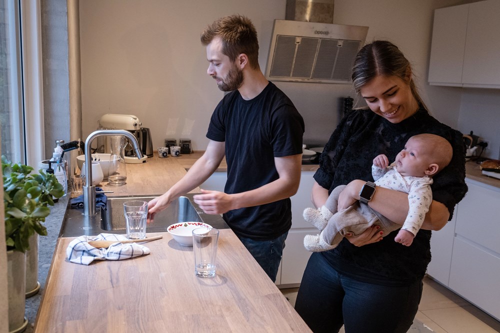 Far og mor med baby i moderne køkken